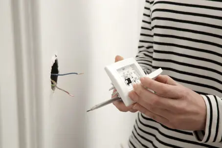 a homeowner fixing an outlet wiring